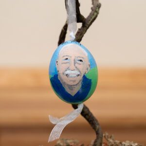 A Pol farm peahen egg painted with a picture of Dr. Pol in a blue shirt